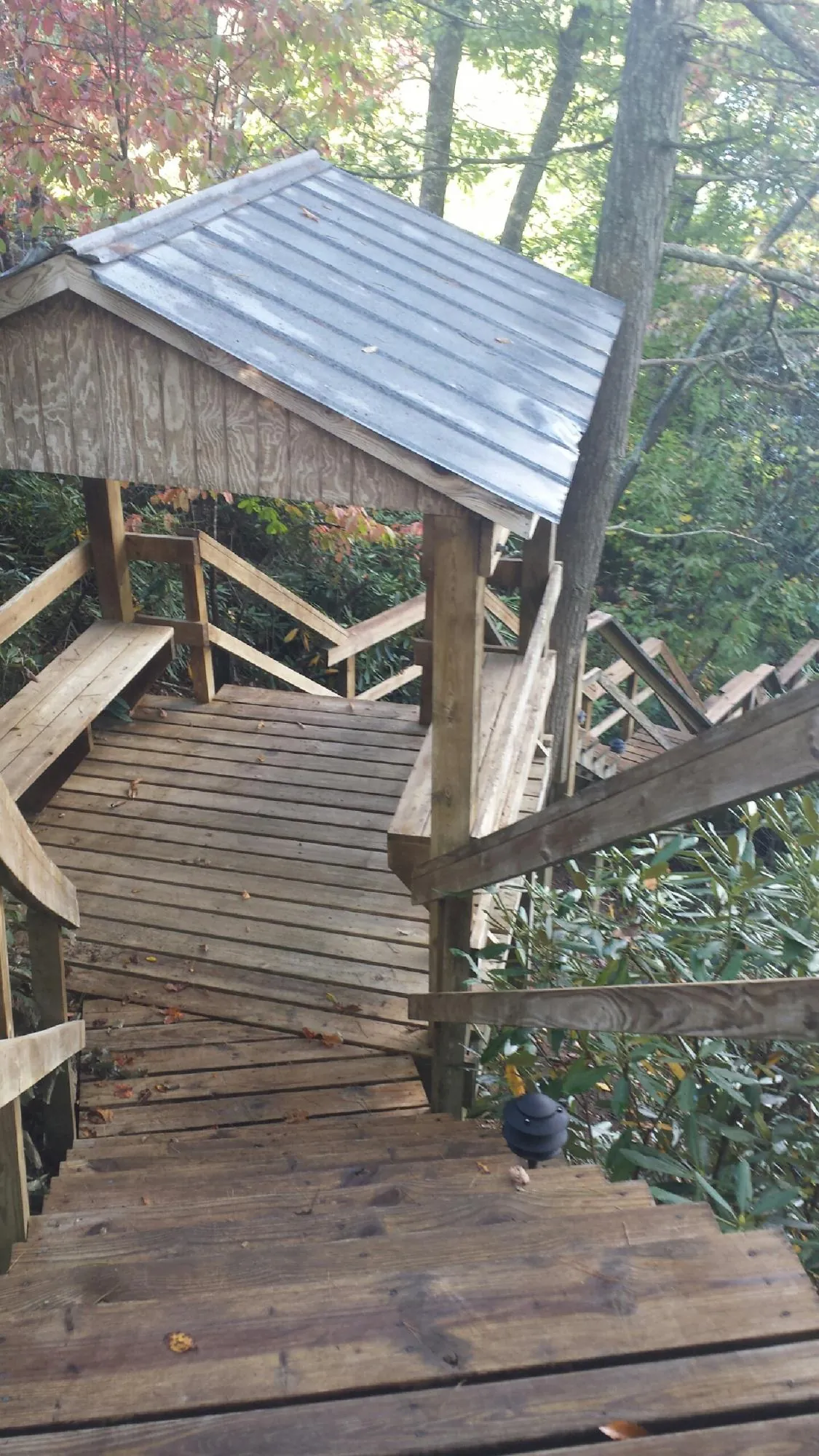 Metal roofed shelter over wooden steps on a wooded walkway — Skylight Repair & Installation work by our crew in Athens
